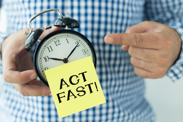 Hand Holding Alarm Clock and Pointing ACT FAST!