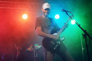 Obraz na płótnie Canvas The guitarist performs on stage.
