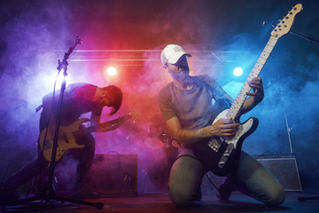 Obraz na płótnie Canvas Guitarist and bass player perform on stage.