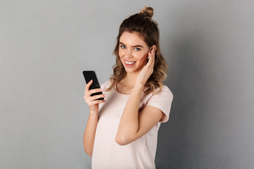 Joyful woman in t-shirt listening music from smartphone