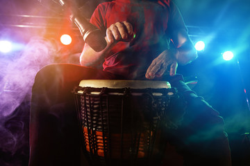 The musician plays the bongo on stage.