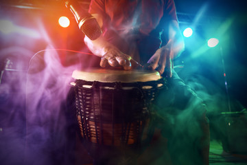 The musician plays the bongo on stage.