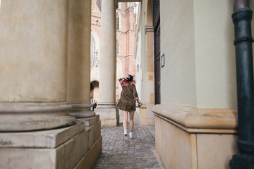 back view of girl with pink hair in trendy dress walking in Wroclaw, Poland