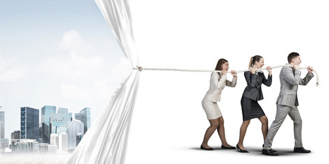 Young businesspeople working in collaboration and pulling white advertisement banner