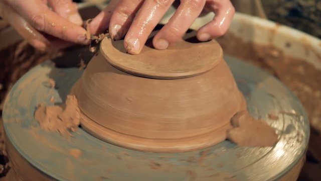 An overturned bowl spins on a potters wheel during final processing. 