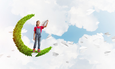 Concept of careless happy childhood with girl on green moon