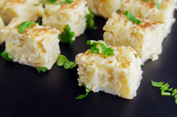 Pinchos  de  Tortilla, Spanish omelette made with eggs and potatoes. Traditional Spanish tapas or snack  on black bacground.
