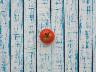 Red tomato on a wooden table