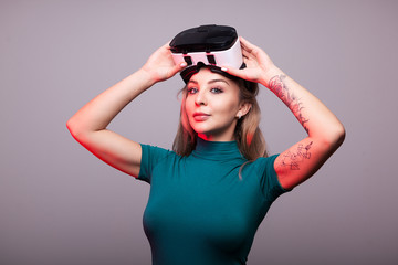 Sexy woman wearing VR virtual reality head set on gray background