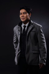 Fototapeta premium Portrait half body, Business Man Stand in gray coat white shirt black pants, studio
