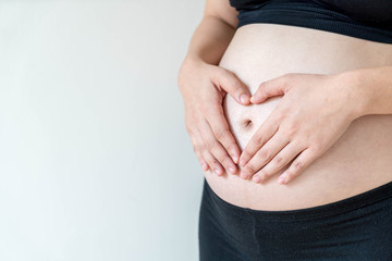 Belly of pregnant woman with hands