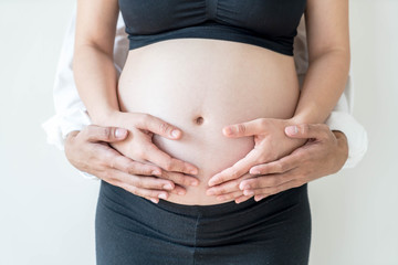 Belly of pregnant woman with hands and her husband hands