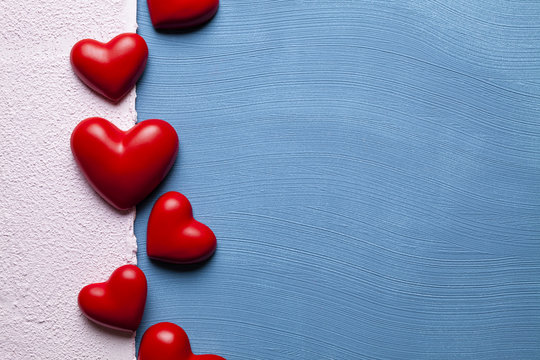 Red hearts on blue and pink plastered background