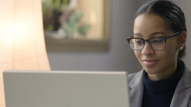 Black female working at her computer in modern setting