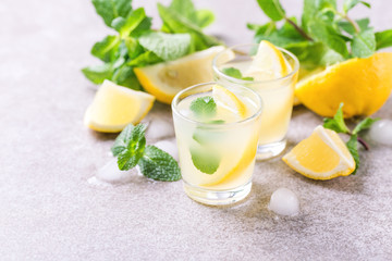 Obraz na płótnie Canvas Italian lemon lime liqueur limoncello with ice and mint