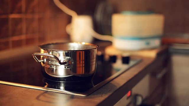 Water boiling in a pot on kitchen stove, food preparation