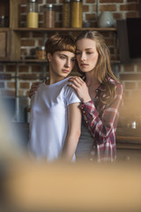 beautiful young lesbian couple on kitchen at home