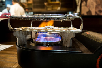 orange and blue flames coming a japanese gas stove