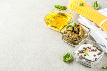 Food background, ingredients for cooking dinner.  Pasta spaghetti, vegetables, sauces and spices, grey stone background copy space