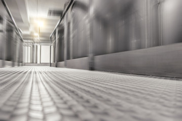 Metal floor in the factory between large metal barrels. Motion blur