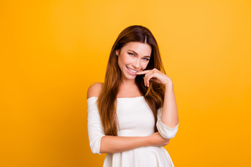 Portrait of beautiful attractive adorable graceful elegant dreamy rich luxurious fashionable woman touching lips holding hand on waist isolated on yellow background