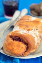 bread with smoked sausage on plate and red wine