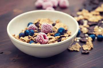 flakes with berries in brown bowl