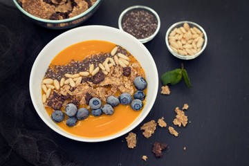 puree of mango with granola, chia and berries in white bowl