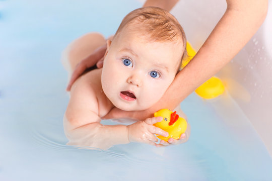 Baby swimming with yellow toy duck