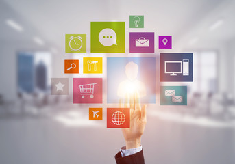 Modern office interior and close of businesswoman hand choosing icon on multimedia interface