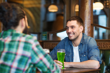 male friends drinking green beer at bar or pub