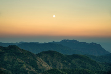 Fototapeta premium Moon rises on mountain after sunset : Thailand