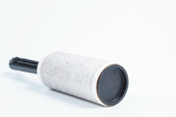 Adhesive lint roller with sticky paper full of hair and dust