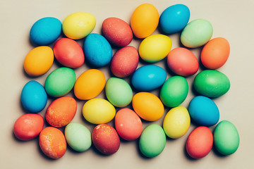 Fototapeta na wymiar Colorful eggs on a creamy background.