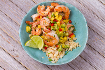 Shrimps with mango avocado and red pepper salsa on cauliflower rice