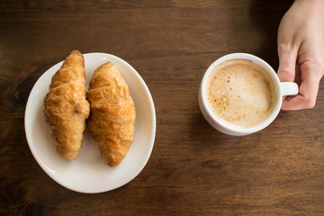 Taking in the morning a delicious breakfast with chocolate croissants and coffee with milk