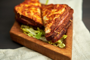 grilled sandwich on a wooden board, baked cheese