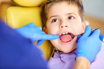 The dentist checking the teeth of  boy teenager in the dentist's office.