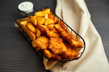 Nuggets and baked potatoes in a beautiful basket with white sauce