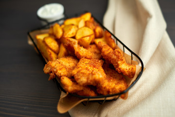 Nuggets and baked potatoes in a beautiful basket with white sauce