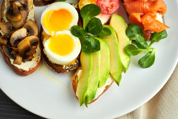 Bruschetta, assorted, different fillings, on plates with a soft-boiled egg in the middle