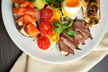 Bruschetta, assorted, different fillings, on plates with a soft-boiled egg in the middle