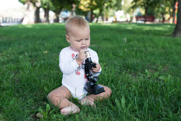 Fototapeta na wymiar student little girl with microscope - working outside in nature