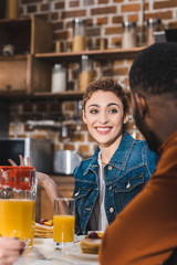 cropped shot of smiling young multiethnic couple having breakfast together at home