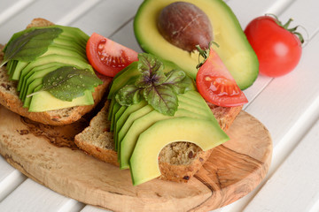 Sandwich with avocado and poached egg - healthy breakfast concept