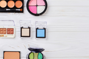 Eyeshadows kit on white wooden background. Professional make up eyeshadows and copy space. Fashion style cosmetics.