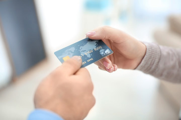 Man giving credit card to woman, closeup