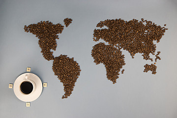 on a blue background scattered coffee beans and stands a white Cup with black coffee in it