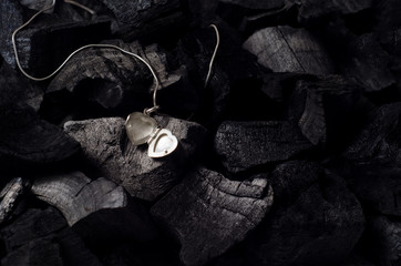 Silver heart  shape locket with necklace on black charcoal texture background