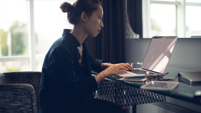 Young woman using a laptop while sitting at table